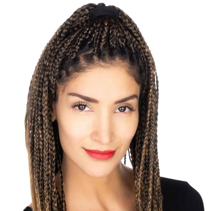 Headshot of a woman with long braids tied half up and red lipstick, slight smile, in a black top, on a white background